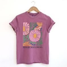 Looking for a cute versatile top to wear? Make sure to grab one of our Graphic tees! This soft and comfortable graphic tee is the perfect top for any outfit. It can be paired with biker shorts, jeans, or even a simple skirt/dress! This tee is true-to-size, so be sure to order your regular t-shirt size! If you are looking for a more oversized look, make sure to size up! Artsy Graphic Tees, Merch Tshirt Design, Fun T Shirts, Goblin Mode, Purple Graphic Tee, Mom T Shirts, Hippie Blouse, Flowers Graphic, Simple Skirt