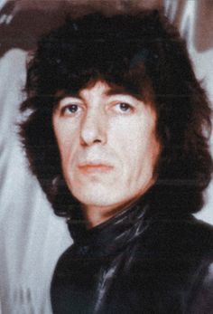 a man with long hair wearing a black leather jacket