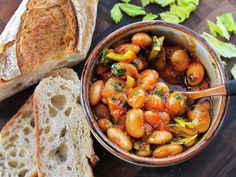 a bowl of chickpeas and bread on a cutting board