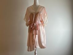 Vintage Val Mode Lingerie pink belted robe with floral and lace detail on sleeves.  The robe body is semi sheer.  100% polyester.  Made in the U.S.A.  Please note this is a vintage item and does show signs of ware such as pilling of fabric and small snags.  Most notable is a snag on the back (see photo).  In overall good vintage condition with no rips, stains, holes, or tears. Labeled size large but fits best as modern small to medium.  Displayed on size 6 mannequin.   Approximate measurements: 37" top to bottom 38" wide (adjustable) Lingerie Rosa, Lingerie Pink, Belted Robe, Bridal Party Robes, Rose Vintage, Mode Vintage, Bridesmaids Gifts, Top To Bottom, Lace Detail