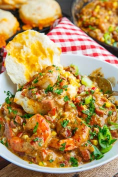 a bowl filled with food sitting on top of a red and white checkered table cloth