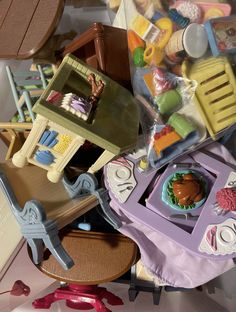 a pile of toys sitting on top of a white floor next to a chair and table