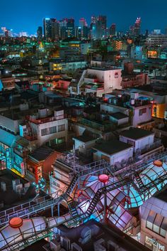 an aerial view of a city at night with buildings lit up in blue and red