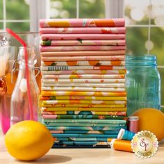 there are many different types of fabric on the table next to some bottles and oranges