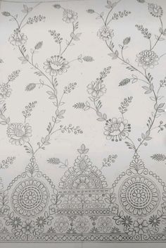 a white and grey wallpaper with floral designs on the side, next to a window