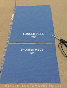 two pieces of blue fabric with scissors on them and measuring tape to measure the length