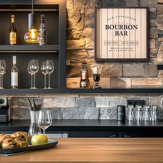 a bar with wine glasses and bottles on the counter, next to an empty tray