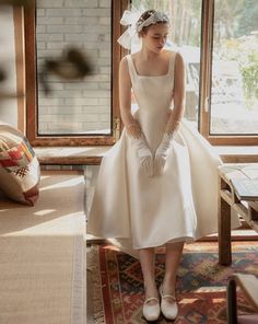 a woman in a white wedding dress and gloves