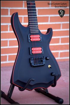 an electric guitar sitting on a stand in front of a brick wall with red lights