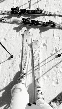 someone is standing on skis in the snow with their feet propped up against them