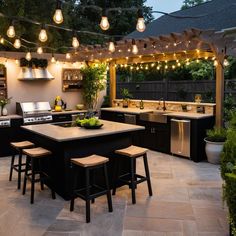 an outdoor kitchen is lit up with lights