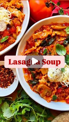 two white bowls filled with lasagna soup on top of a table next to vegetables