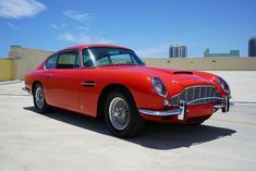 an old red car is parked in the parking lot