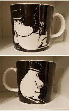 two black and white coffee mugs with cartoon characters on them