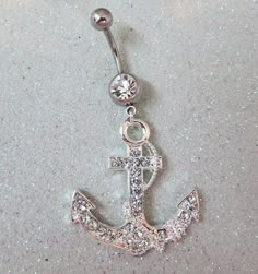 an anchor belly ring with crystal stones on it