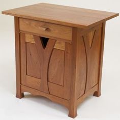 a small wooden cabinet with two doors on one side and an open drawer on the other