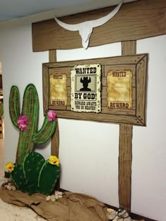 a cactus sits in front of a sign that says wanted by god and is next to a fake cactus