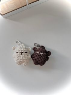 two crocheted keychains sitting next to each other on a white surface