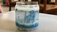 a jar filled with blue liquid sitting on top of a table