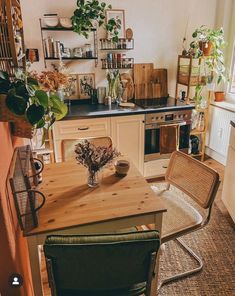 a kitchen filled with lots of wooden furniture and plants on top of the counter tops