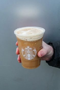 a person holding up a cup of coffee