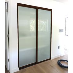 an empty room with sliding glass doors and hard wood flooring on the side wall