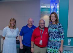 four people posing for a photo in an office