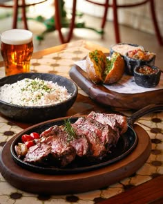 steak and rice on a table with beer