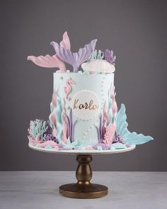 a cake decorated with sea creatures and the word kora on top is sitting on a pedestal