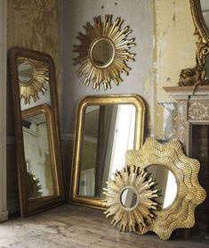 three mirrors sitting on top of a wooden floor next to a fire place and a fireplace