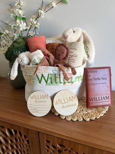 a basket filled with stuffed animals sitting on top of a wooden table next to a book