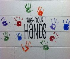 hand prints on a wall with the words wash your hands