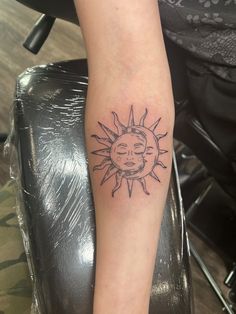 a woman's arm with a sun tattoo on the left side of her leg