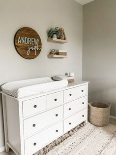 a baby crib in the corner of a room with a wooden sign above it