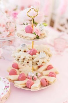 three tiered trays filled with cookies and pastries on top of a table