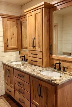 a bathroom with double sinks and wooden cabinets