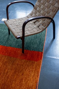 a chair sitting on top of a rug next to a metal frame and wooden legs