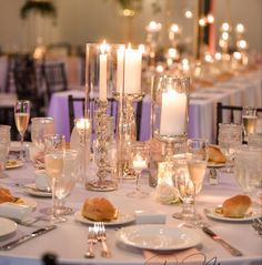 the table is set with glasses, plates and silverware for an elegant dinner party