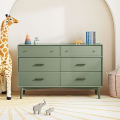 a toy giraffe standing next to a dresser in a child's room