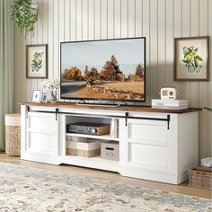 a flat screen tv sitting on top of a white entertainment center in a living room