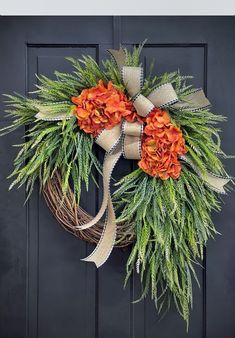 a wreath with orange flowers is hanging on the front door