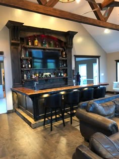 a living room with leather couches and a bar in the middle of the room