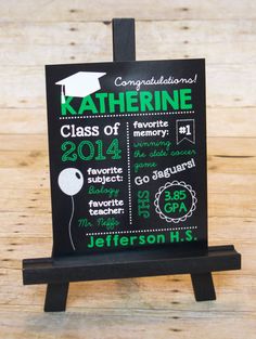 a chalkboard sign with graduation decorations on it and the names of graduates in green