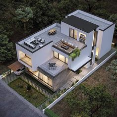 an aerial view of a modern house in the middle of some trees and bushes at night