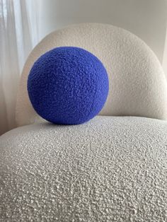 a blue ball sitting on top of a white chair