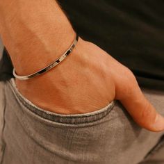 Juan silver bracelet for men is handcrafted, long-lasting, and adjustable to accommodate any wrist size. SAAR's men's cuff bracelets are a must-have for every collection, and they're suitable for all lifestyles. This silver cuff bracelet is ideal for everyday use, the office, or a night out. The Juan Cuff captures light from all directions thanks to its tapering edges, resulting in next-level shine. -Water, sweat and heat resistant -Premium 316L Stainless & Rhodium Base -No Discolouring or Tarni Classic Bracelets For Everyday And Father's Day, Classic Everyday Bracelets For Father's Day, Modern Cuff Wristband As Gift, Silver Bangle Wristband For Everyday, Minimalist Formal Cuff Bracelet, Modern Bracelets For Father's Day, Modern Band Bracelet As Gift, Masculine Bracelets For Father's Day, Modern Band Bracelets For Gifts