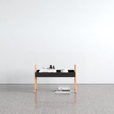 a black table sitting on top of a white floor next to a book shelf with books