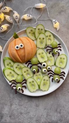 a white plate topped with cucumbers and slices of fruit covered in googly eyes