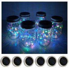 four mason jars with lights in them sitting next to each other