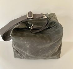 "This waxed canvas crossbody bag made of 10 oz fabric is water repellant, lightweight and beautiful! I've had this on my \"to do\" list for quite some time now. This bag is simple, sturdy and comfortable to wear and use. Fabric is doubled on the bottom and #5 nylon coil zipper with two pulls. Key hook inside. Choose from 4 colors and two hardware finishes. Charcoal is shown in the first few photos, then Olive, last photo is dark brown. Leather strap attachment may differ a little from photos. Pl Waxed Canvas Tote Bag, Waxed Canvas Backpack, Waxed Canvas Bag, Casual Tote Bag, Grey Bag, White Brass, Key Hook, Canvas Crossbody Bag, Waxed Canvas